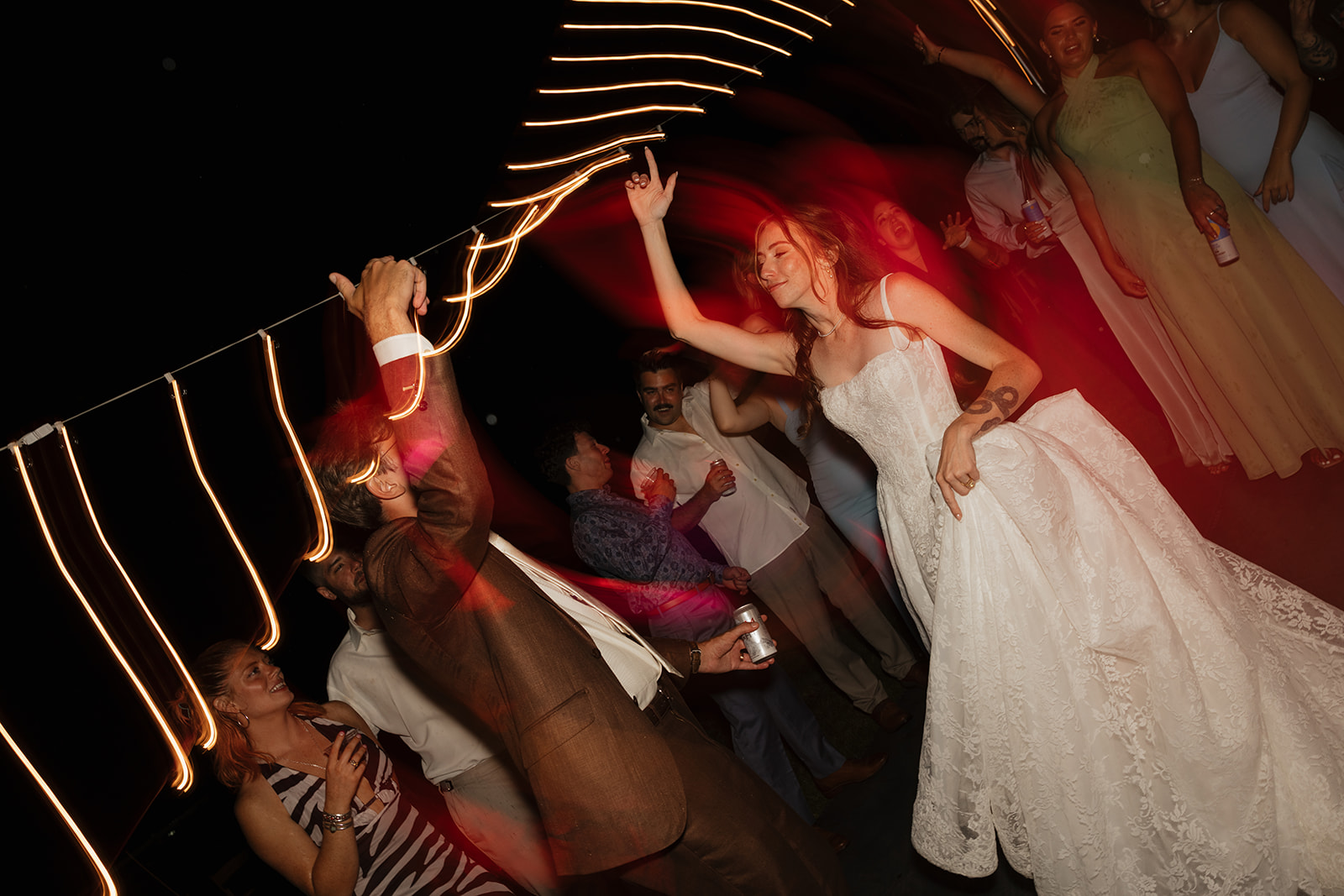 Bride dancing under glowing lights at a lively reception